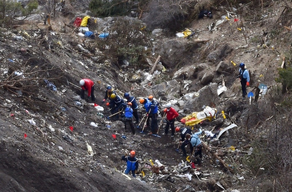 TOPSHOT - -- AFP PICTURES OF THE YEAR 2015 -- French gendarmes and investigators work on March 26, 2015 in the scattered debris on the crash site of the Germanwings Airbus A320 that crashed in the French Alps above the southeastern town of Seyne. The young co-pilot of the doomed Germanwings flight that crashed on March 24, appears to have "deliberately" crashed the plane into the French Alps after locking his captain out of the cockpit, but is not believed to be part of a terrorist plot, French officials said on March 26, 2015. AFP PHOTO / ANNE-CHRISTINE POUJOULAT / AFP / ANNE-CHRISTINE POUJOULAT