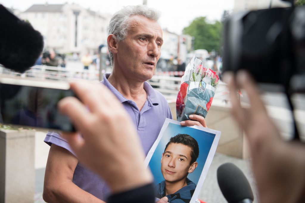 Un père montre lune photo de son fils tué durant l'attaque. (photo AFP)