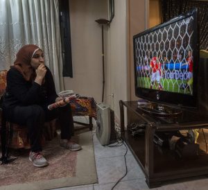 Football analyst Manar Sarhan watches the Euro 2016 quarter-final between Wales and Belgium at her home in the Egyptian capital Cairo on July 1, 2016. The 27-year-old woman who works as a dentist at a government medical centre appears weekly on the private CBC television channel to comment on matches in the competition, a rare sight in a field monopolised by former football players, all of them men. - TO GO WITH AFP STORY BY HAITHAM EL-TABEI / AFP / KHALED DESOUKI / TO GO WITH AFP STORY BY HAITHAM EL-TABEI