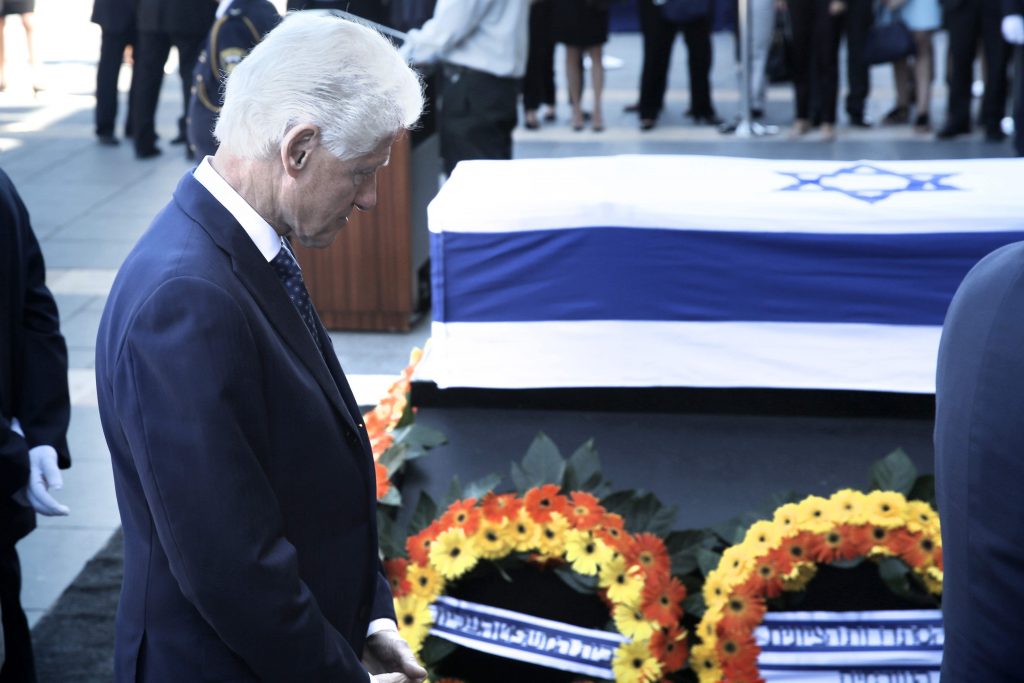 Former US president, Bill Clinton pays his respect in front of the coffin of former Israeli president Shimon Peres at a plaza outside the Knesset, Israel's Parliament, on September 29, 2016 in Jerusalem.  Israeli leaders and crowds of mourners are gathering outside parliament to pay last respects to ex-president and Nobel Peace Prize winner Shimon Peres, whose body is lying in state. The former US president had helped usher in the Oslo peace accords of the 1990s, which resulted in the Nobel prize for Peres, who died on Wednesday aged 93. / AFP / MENAHEM KAHANA