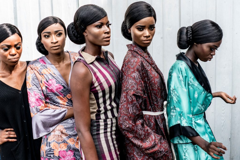 (FILES) This file photo taken on June 03, 2017 shows models displaying their make up to stage managers and designers ahead of the final dressing up at the Africa Fashion Week in Lagos. With more than 500 ethnic groups, Nigeria is able to draw from a huge catalogue of fabrics, styles and jewellery. The beauty of each ethnic look is a source of pride, which has begun to extend beyond Nigeria's borders. / AFP / MARCO LONGARI