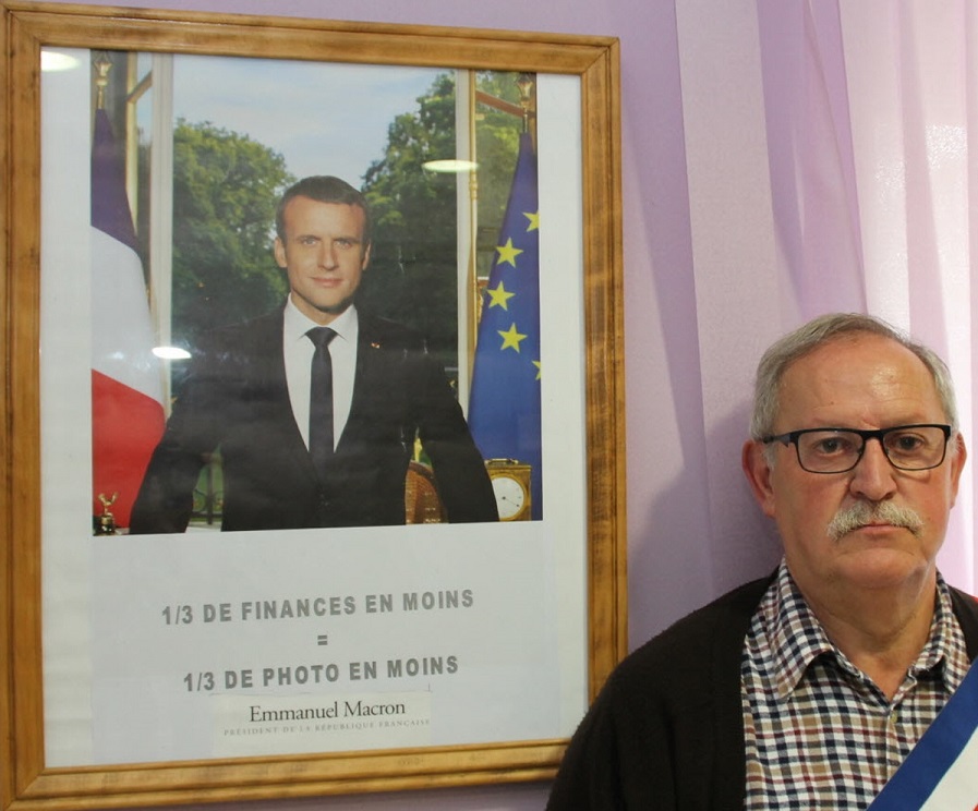 Jean-François Damien devant la photo présidentielle qu’il a retouchée, l’amputant d’un tiers. (Photo RL)