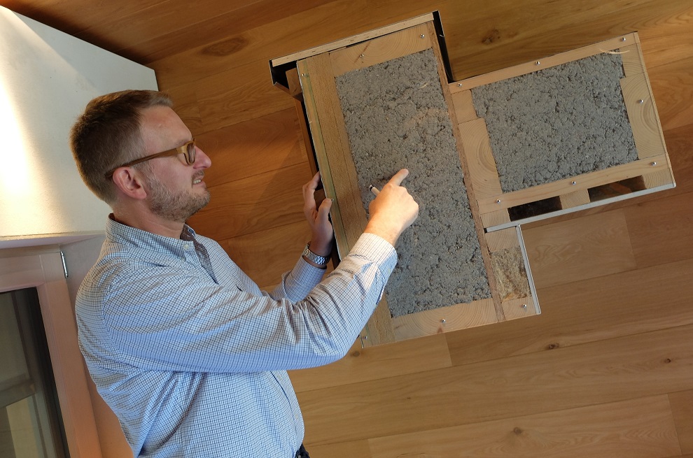 Olivier Louis présentant l'isolation à l'intérieur d'un mur en bois. 